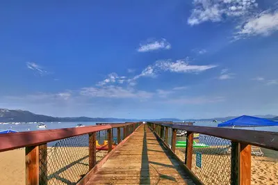 a wooden boardwalk on a beach with the ocean at South Lake Tahoe Resort - Steps to Beach & Close to Heavenly in South Lake Tahoe