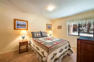 a bedroom with a bed and two lamps and a window at Bruin's Den in Wawona