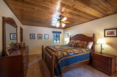 a bedroom with a bed and a wooden ceiling at Bruin's Den in Wawona