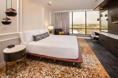 a hotel room with a bed and a desk and a large window at J Resort in Reno