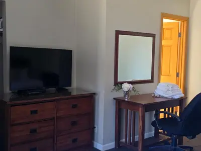 a room with a television and a desk with a mirror at A&A Lake Tahoe Inn in South Lake Tahoe