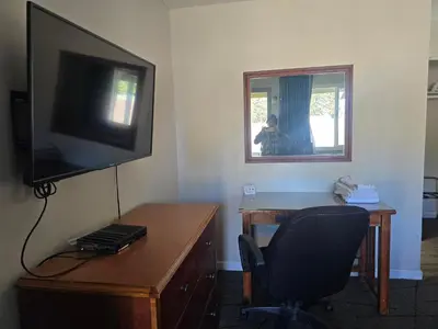 a room with a desk with a television and a chair at A&A Lake Tahoe Inn in South Lake Tahoe