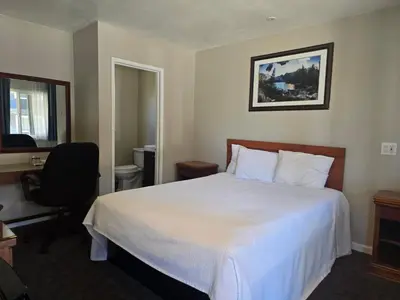 a hotel room with a bed and a desk and a chair at A&A Lake Tahoe Inn in South Lake Tahoe