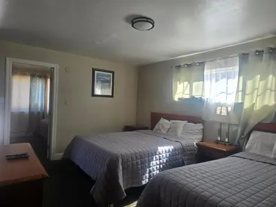 a hotel room with two beds and a window at A&A Lake Tahoe Inn in South Lake Tahoe
