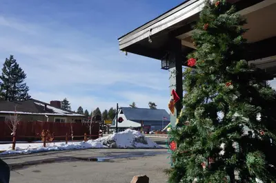 a christmas tree in front of a building with snow at A&A Lake Tahoe Inn in South Lake Tahoe