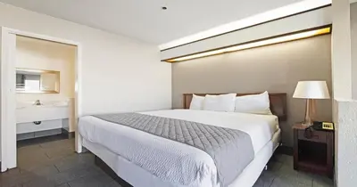 a hotel room with a bed and a window at Budget Inn and Suites Stockton Yosemite in Stockton