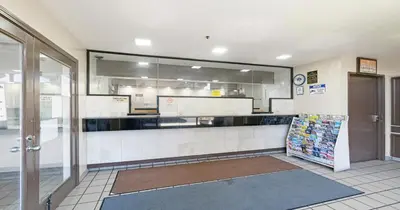 a large kitchen with a counter in a restaurant at Budget Inn and Suites Stockton Yosemite in Stockton
