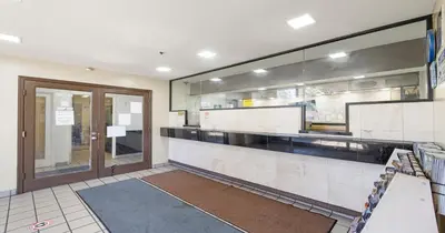 a kitchen with a counter and a large window at Budget Inn and Suites Stockton Yosemite in Stockton