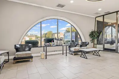 a waiting room with chairs and a table and windows at Heritage Inn Express Roseville in Roseville