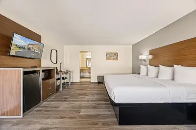 a hotel room with a large bed and a desk at Heritage Inn Express Roseville in Roseville