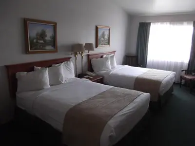 a hotel room with two beds and a window at Garden Inn and Suites Fresno in Fresno