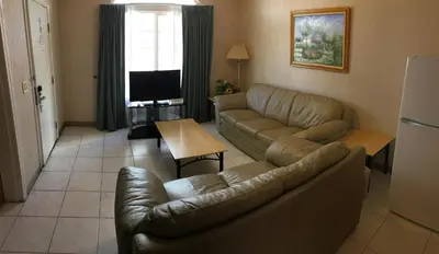 a living room with a couch and a television at Garden Inn and Suites Fresno in Fresno