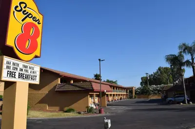 a sign for a fast food restaurant in a parking lot at Super 8 by Wyndham Visalia in Visalia