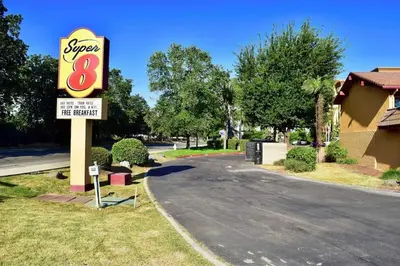 a sign for a super motel and a sign for at Super 8 by Wyndham Visalia in Visalia