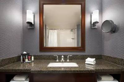 a bathroom with a sink and a mirror at Visalia Marriott at the Convention Center in Visalia
