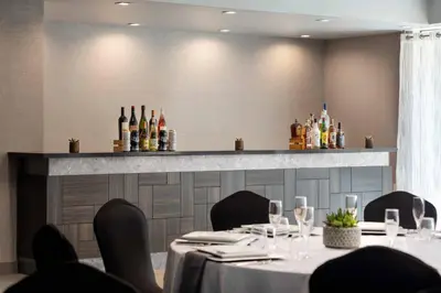 a dining room with a table and bottles of wine at Visalia Marriott at the Convention Center in Visalia