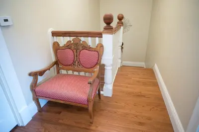a wooden chair with a pink seat in a hallway at Poppy Sister Inn in Lodi