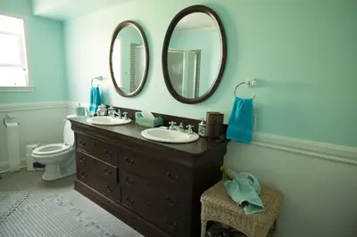 a bathroom with two sinks and two mirrors on the wall at Poppy Sister Inn in Lodi