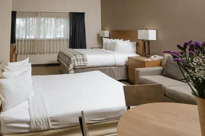 a hotel room with two beds and a couch at Mammoth Mountain Inn in Mammoth Lakes