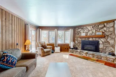 a living room with a couch and a stone fireplace at Mountainback 47 in Mammoth Lakes