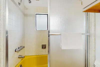 a bathroom with a yellow tub and a shower at Saddle Road Condo in Bijou Park