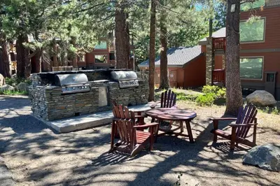 a picnic table and chairs and a grill in a yard at The Summit 206 in Old Mammoth