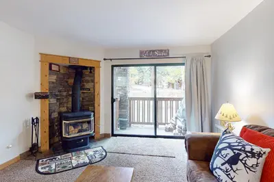 a living room with a couch and a wood stove at The Summit 206 in Old Mammoth