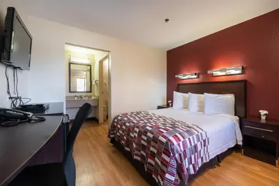 a hotel room with a bed and a flat screen tv at California Inn and Suites, Rancho Cordova in Rancho Cordova