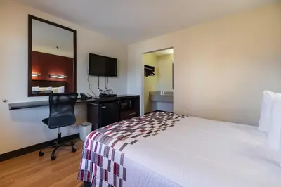 a hotel room with a bed and a desk and a chair at California Inn and Suites, Rancho Cordova in Rancho Cordova