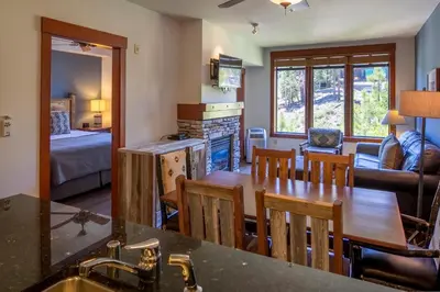 a kitchen and living room with a table and chairs at The Village Lodge in Mammoth Lakes