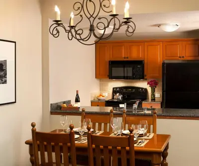a dining room with a table and a kitchen at The Village Lodge in Mammoth Lakes