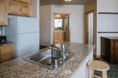 a kitchen with a sink and a white refrigerator at Juniper Springs Resort in Mammoth Lakes