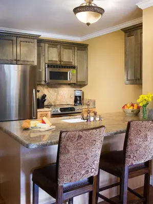 a kitchen with a large island with two bar stools at Juniper Springs Resort in Mammoth Lakes
