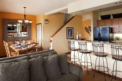 a living room with a couch and a kitchen at Juniper Springs Resort in Mammoth Lakes