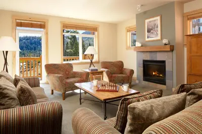 a living room with couches and a fireplace at Juniper Springs Resort in Mammoth Lakes