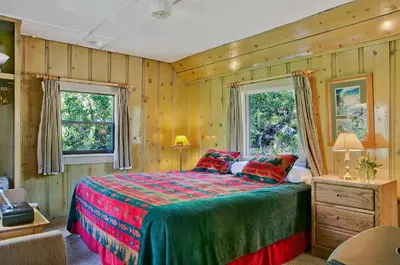 a bedroom with a bed and two windows at Tamarack Lodge in Mammoth Lakes