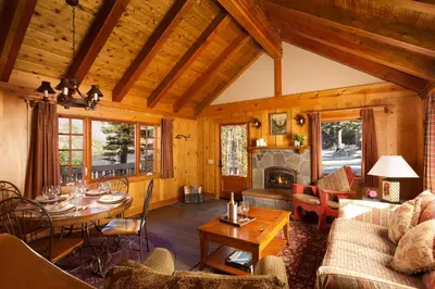 a living room with a table and a fireplace at Tamarack Lodge in Mammoth Lakes
