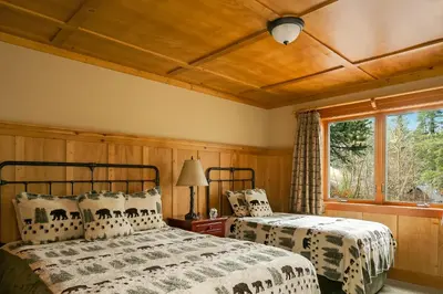 two beds in a bedroom with a window at Tamarack Lodge in Mammoth Lakes