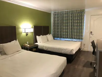 a hotel room with two beds and a window at Gilroy Inn in Gilroy