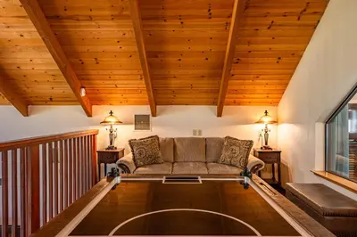 a living room with a couch and wooden ceilings at Mountain View Playhouse Near Yosemite & Bass Lake in Oakhurst