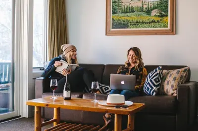 two women sitting on a couch in a living room with a table at Sunnyside Resort and Lodge in Tahoe City