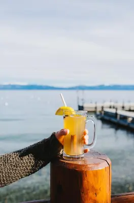 a person holding a glass of orange juice at Sunnyside Resort and Lodge in Tahoe City