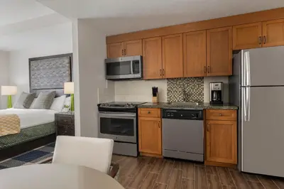 a kitchen with wooden cabinets and a white refrigerator at Marriott Grand Residence Club, Lake Tahoe in South Lake Tahoe