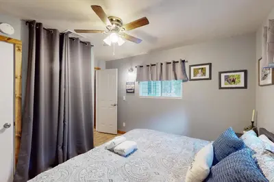 a bedroom with a bed and a ceiling fan at Peaceful Pines Retreat in Mevers