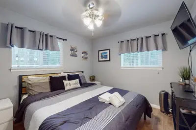 a bedroom with a large bed and a television at Peaceful Pines Retreat in Mevers