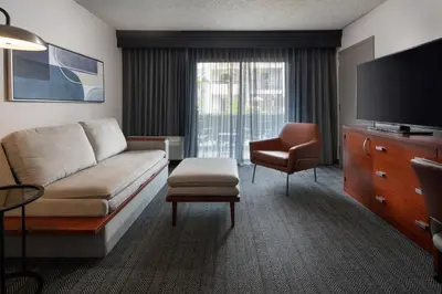 a living room with a couch and a tv and a chair at Courtyard by Marriott Fresno in Fresno