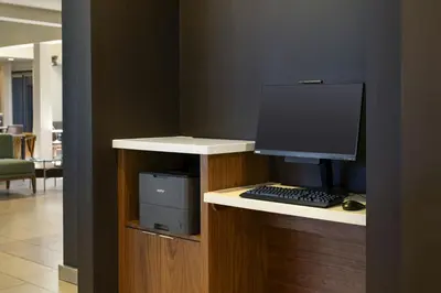 a desk with a computer monitor and a keyboard at Courtyard by Marriott Fresno in Fresno