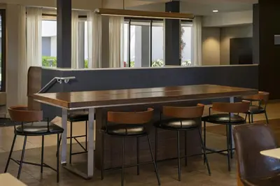 a bar in a restaurant with stools around it at Courtyard by Marriott Fresno in Fresno