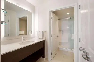 a white bathroom with a sink and a shower at Sonesta ES Suites Reno in Reno