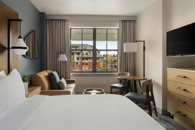 a hotel room with a large white bed and a desk at Marriott's Timber Lodge in South Lake Tahoe